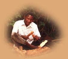 Picture of true carver using his feet to hold the wood as he carved with both hands